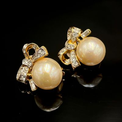 une paire de boucles d'oreilles en perles et diamants sur fond noir