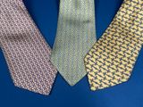 three different colored ties on a blue surface with a blue background