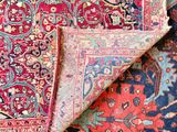 an image of a pile of oriental rugs on a wooden floor