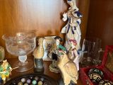 a wooden shelf with a plate of chocolates and figurines on it