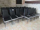 des rangées de chaises noires et blanches dans une pièce aux murs en briques