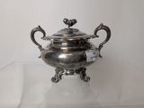 a silver plate with a bird on it on a glass table