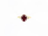 a close up of a ring with a red stone in it