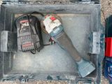 a tool in a case with a cordless drill and other tools