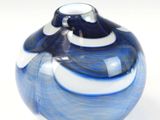 un vase bleu et blanc posé sur une surface blanche