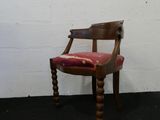 une chaise en bois sur laquelle est posé un coussin rouge