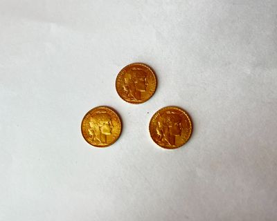 trois pièces d'or posées sur un morceau de papier