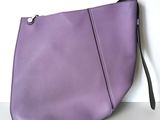 the purple purse is sitting on the table next to the wall