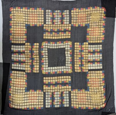 a black pillow with a yellow and red design on it