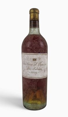 an old bottle of wine sitting on top of a white surface