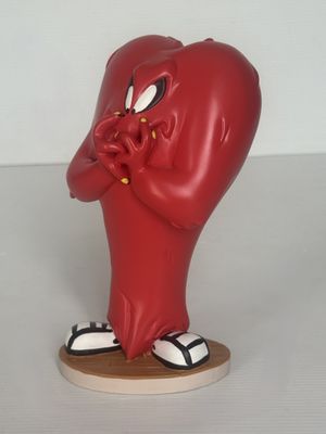 une figurine représentant un cœur rouge posée sur un socle en bois