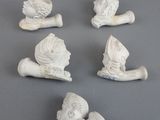 six petites figurines blanches représentant un homme avec un chapeau et une pipe