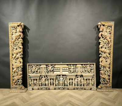 a pair of carved wooden columns with carvings on them