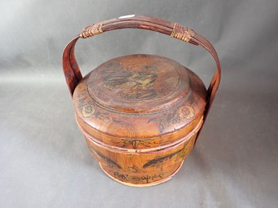 une petite boîte en bois munie d'une poignée, posée sur une table