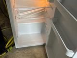 a white refrigerator with its door open in a room