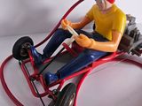 a figurine of a man driving a toy car