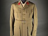 a military uniform on a mannequin stand with a black background
