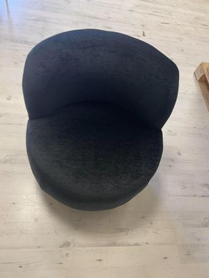 une chaise noire posée sur un parquet en bois dur