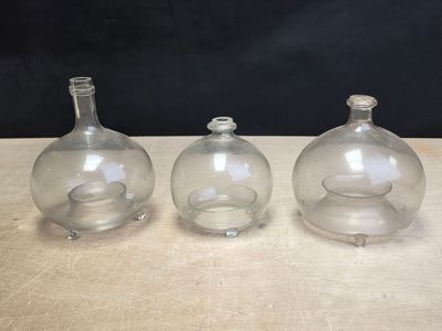 three clear glass vases sitting on top of a wooden table