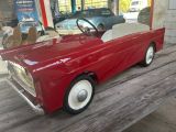 a red toy car that is sitting on a wooden table
