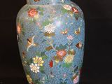 a blue vase with flowers on it on a black background