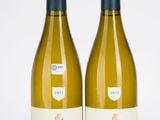 deux bouteilles de vin blanc posées l'une à côté de l'autre sur une surface blanche