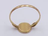 a close up of a gold ring on a white surface