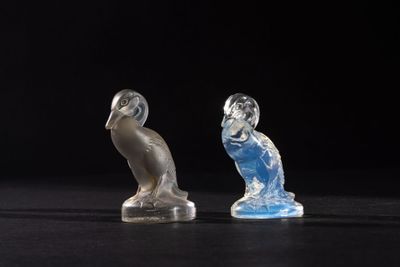 two figurines that are sitting on a black surface