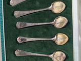 six spoons in a box on a table