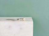 une bague en perle posée sur un bloc de marbre blanc