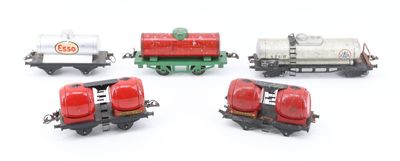 several toy train cars are lined up on a white surface
