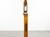an image of a tall wooden clock with a bird on top of it