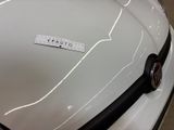 a close up of a white car with a sticker on it