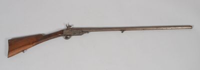 un vieux fusil avec une poignée en bois sur fond blanc