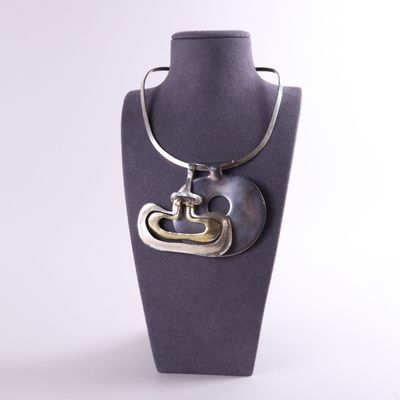 Collier avec un cœur en argent et en or présenté sur un mannequin
