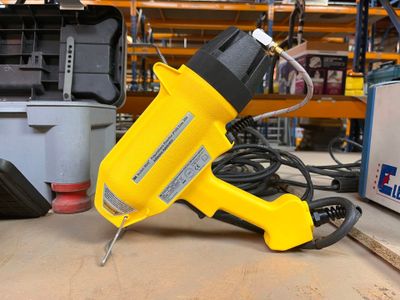 un pistolet à colle électrique jaune et noir posé sur une table
