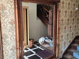 un grand miroir au milieu d'une pièce où se trouve un escalier