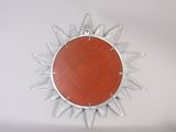 a picture of a metal sunburst hanging on a wall