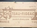 une caisse en bois sur laquelle est accrochée une pancarte indiquant « Château de Figac »