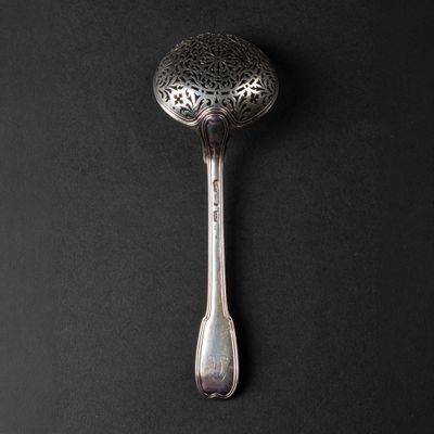 silver spoon on a black surface with a black background