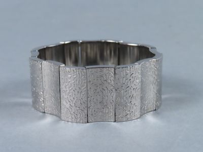 une photo en gros plan d'un bracelet en argent posé sur une surface blanche