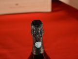a bottle of wine sitting on a table with a red cloth