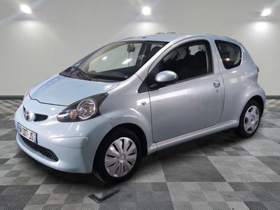 la photo d'une petite voiture argentée garée sur un sol en damier