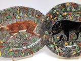 two plates with animals painted on them sitting on a table