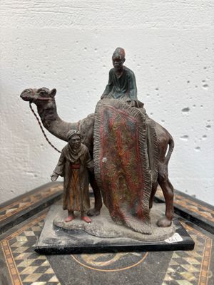 statue représentant un homme à dos de chameau, sur lequel se trouvent deux autres hommes