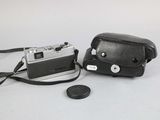 a black camera and a black bag on a white table