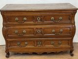 an old wooden chest of drawers with brass hardware on top of it