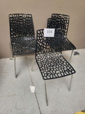 three black chairs with a price tag on them sitting on a floor