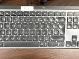 a computer keyboard sitting on top of a wooden table