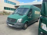 deux camions verts garés l'un à côté de l'autre devant un immeuble